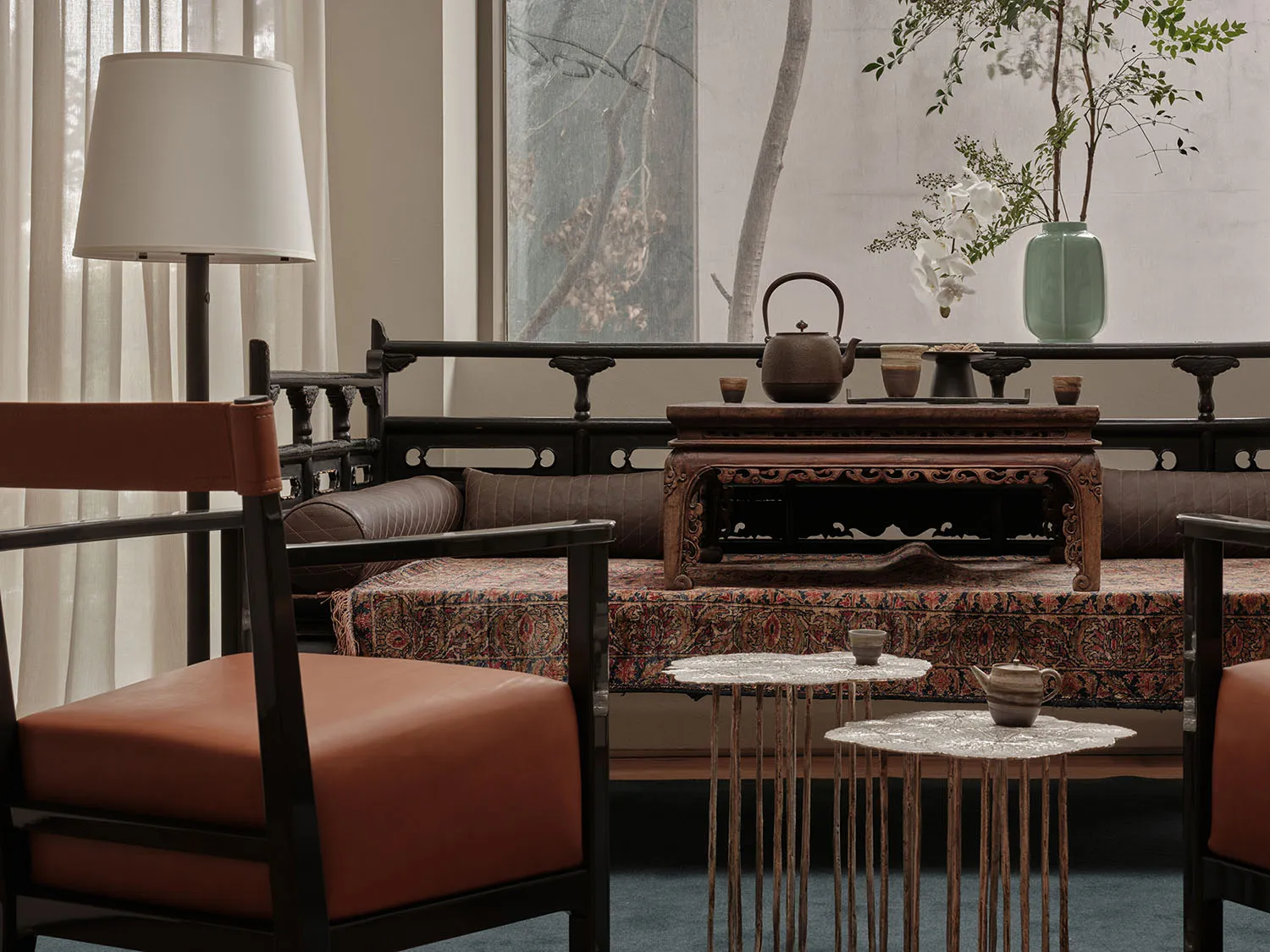 Modern living room featuring a combination of sleek, teak furniture and traditional decorative items, including a vase with g