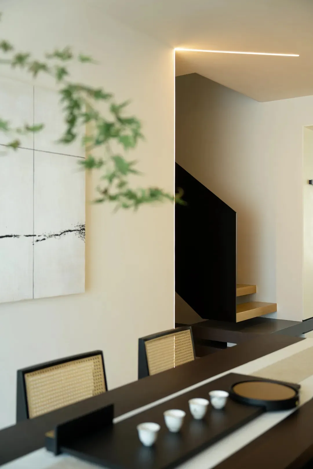 Modern dining room with concrete walls, wooden table and chairs, and minimalist decor.
