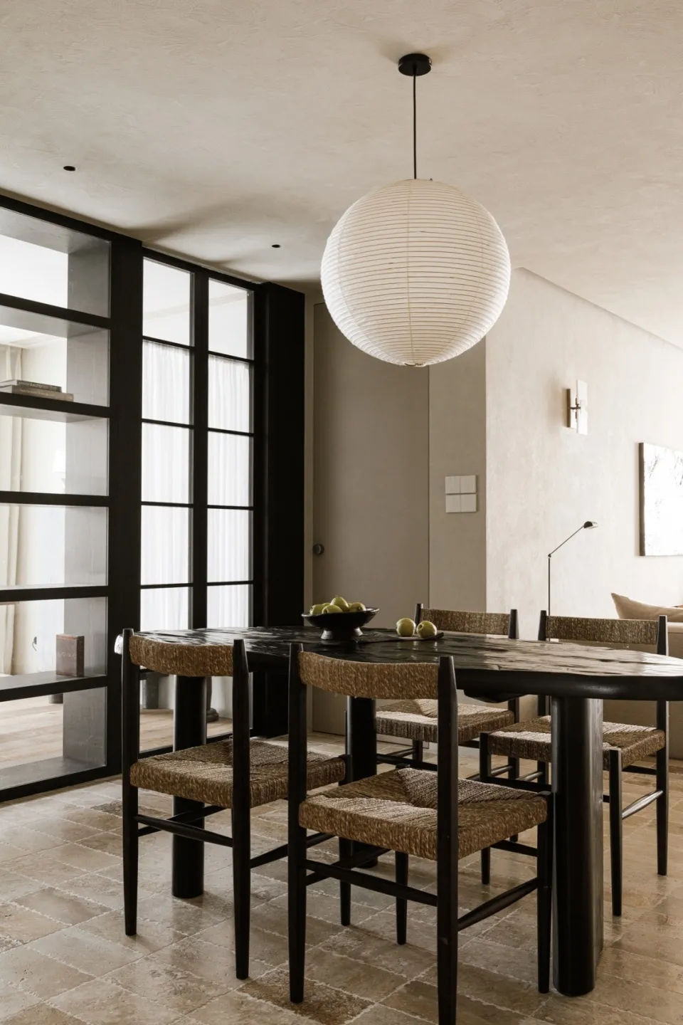 Modern dining room with wooden furniture and a round light fixture.