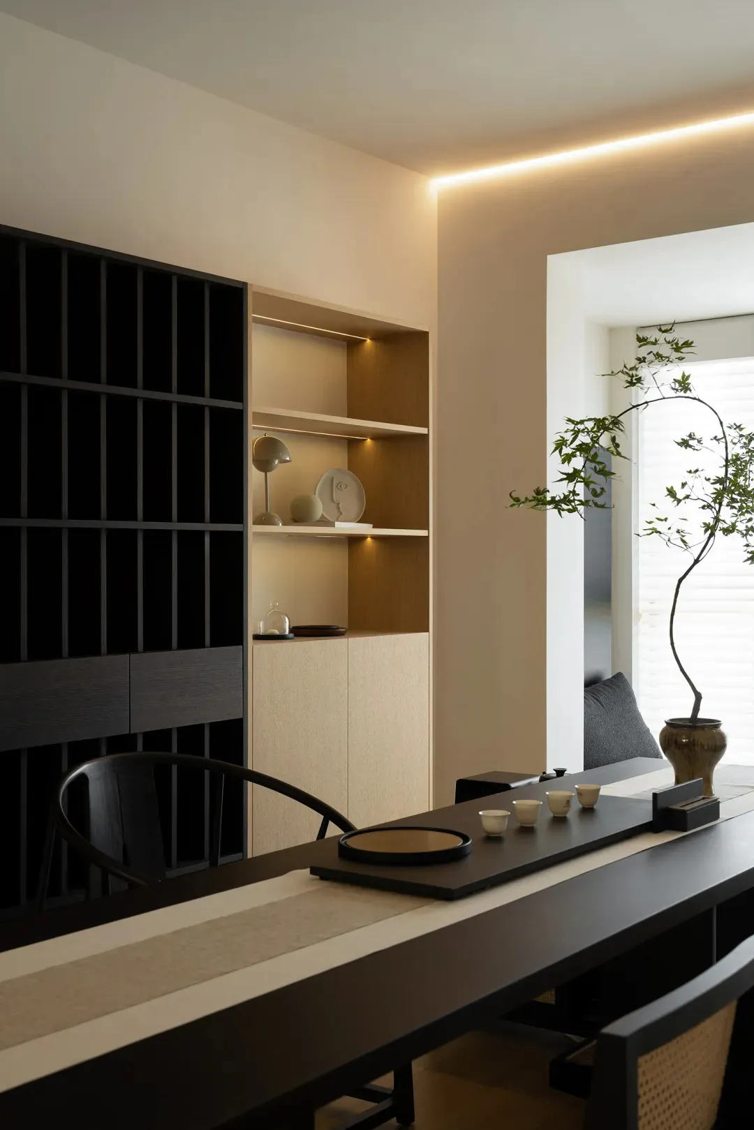 Modern home office featuring a wooden desk and shelving unit with abstract sculptures and lighting.