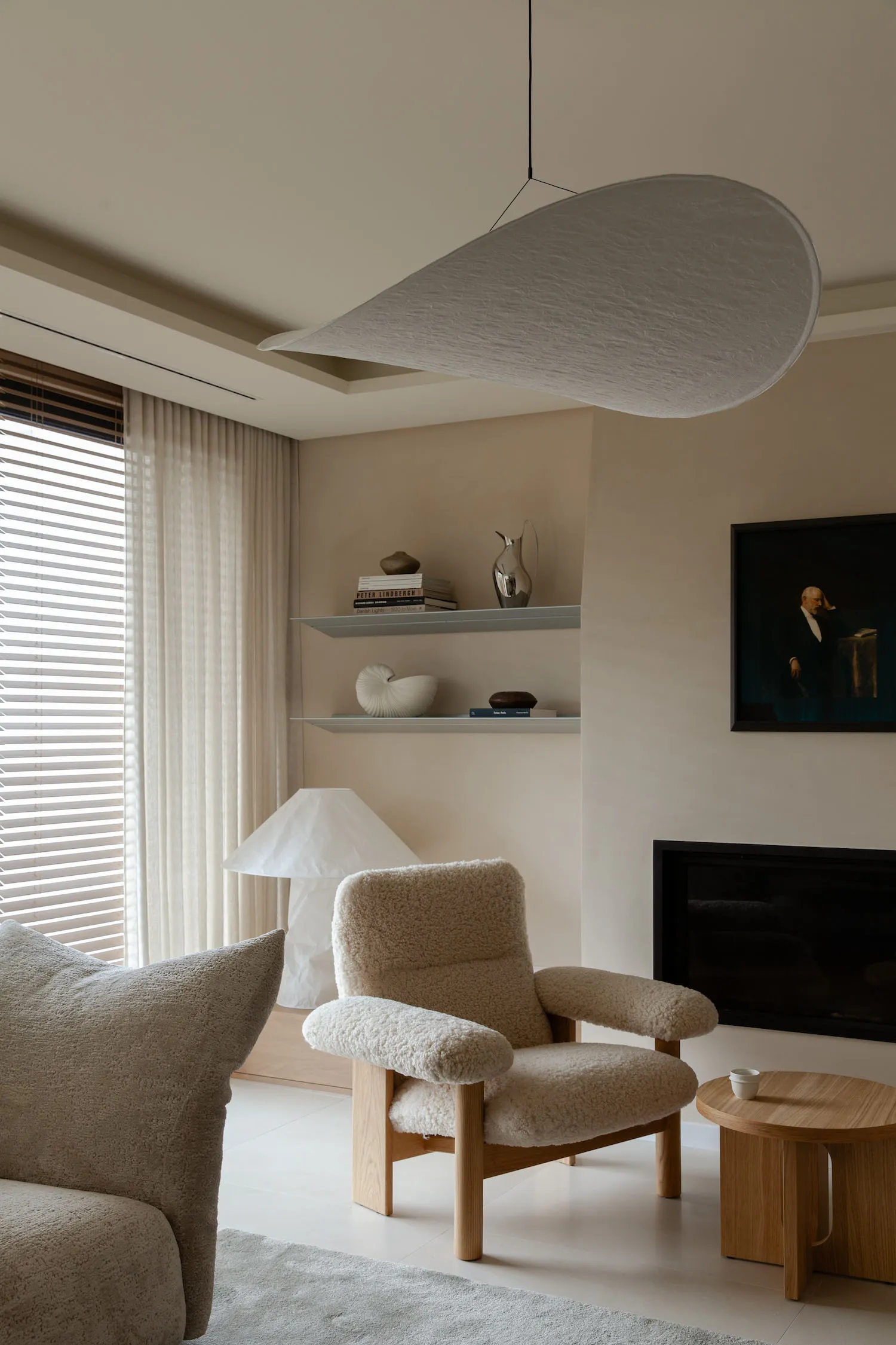 Minimalist modern living room with textured shelving and cozy seating arrangements.