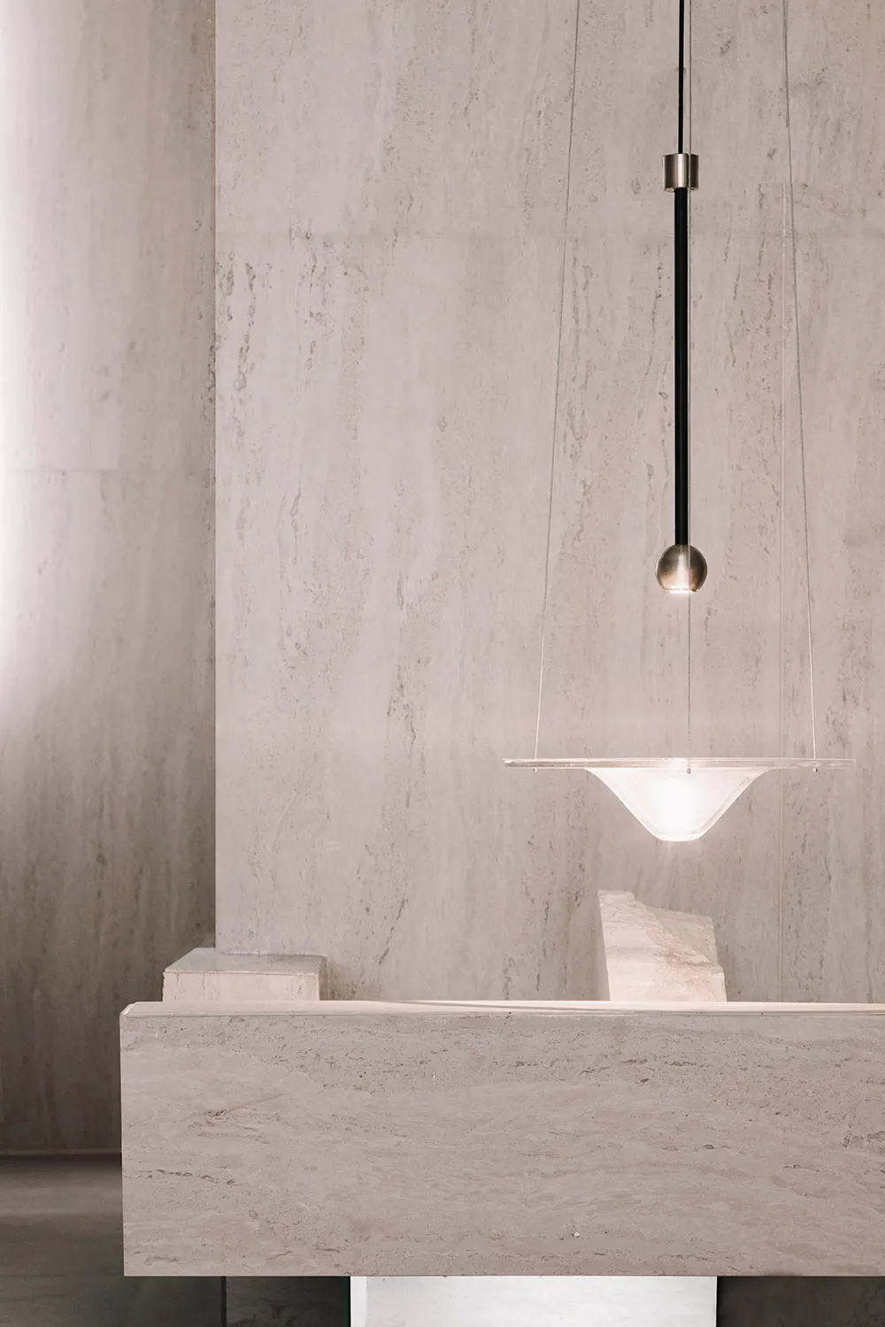 Minimalist modern contemporary bar interior with light fixture and marble countertop.