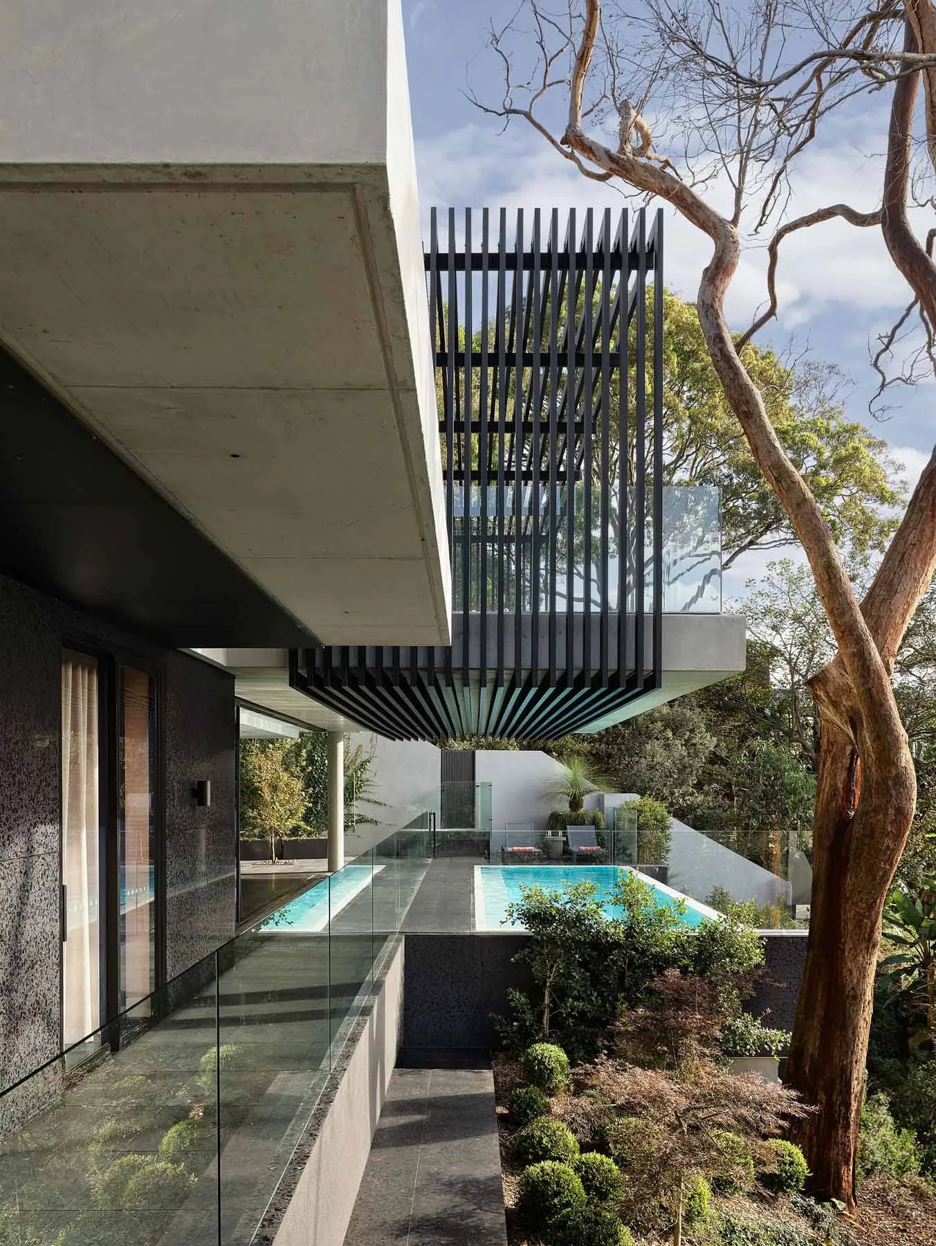 Outdoor contemporary residential area showcasing modern minimalist architecture with concrete and glass materials.
