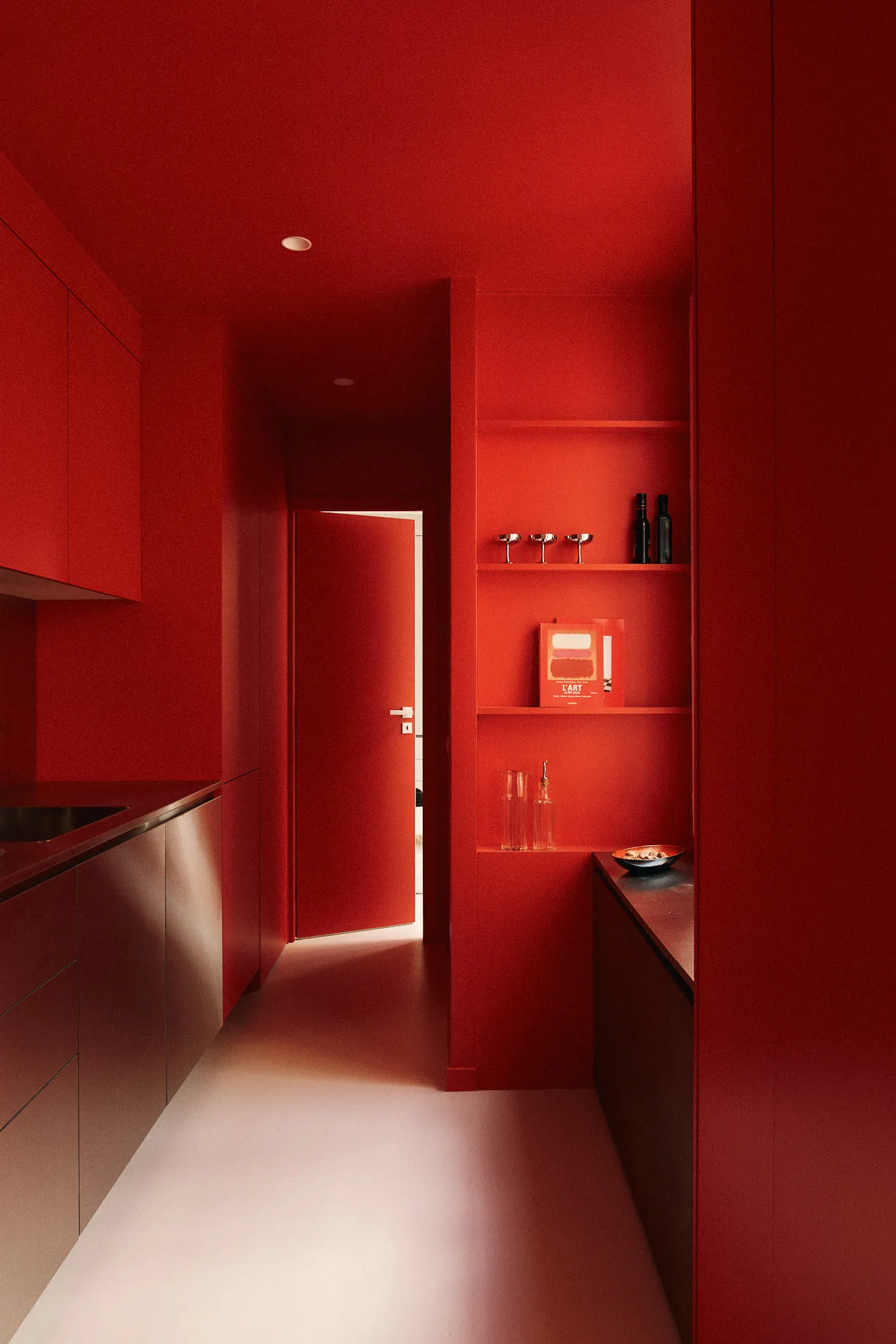 Modern red kitchen with integrated storage solutions and minimalist design.
