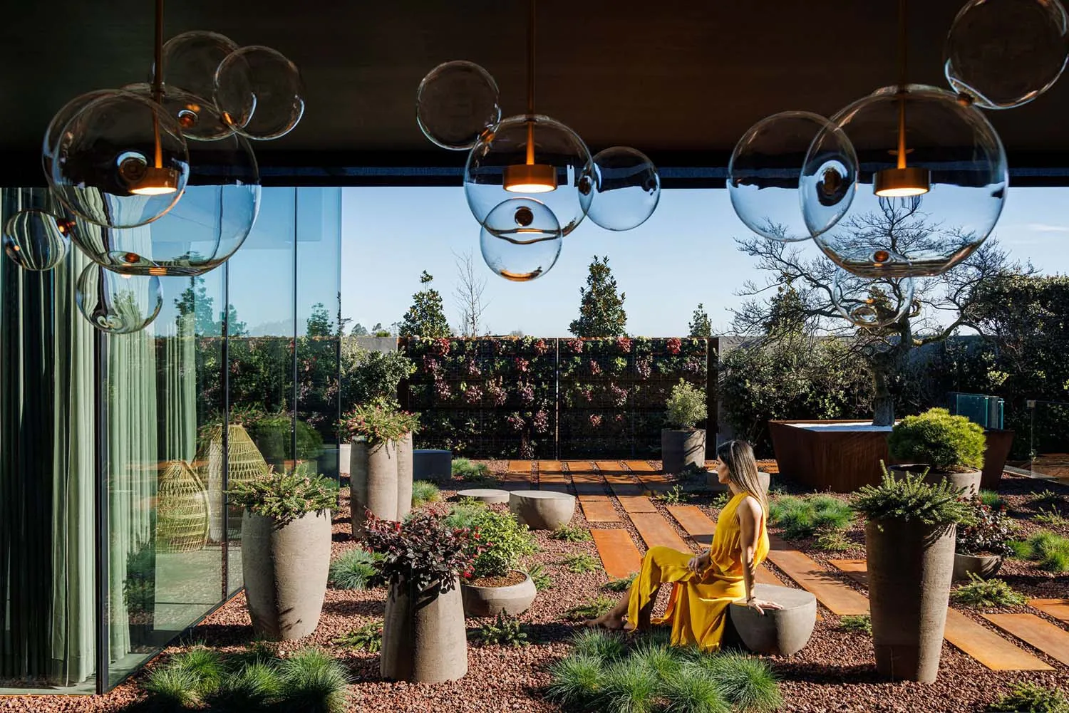 A modern interior featuring a living space with concrete and glass elements