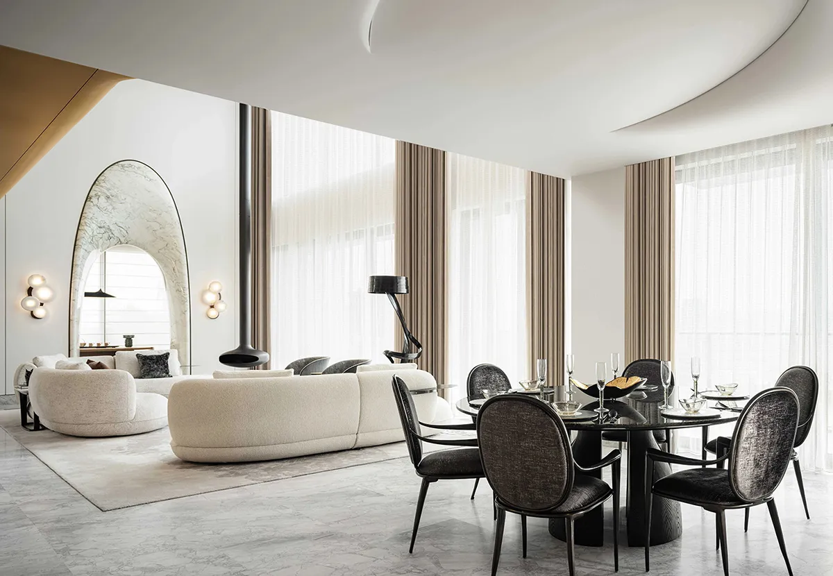 A modern, luxurious living and dining room featuring marble finishes and elegant decor.