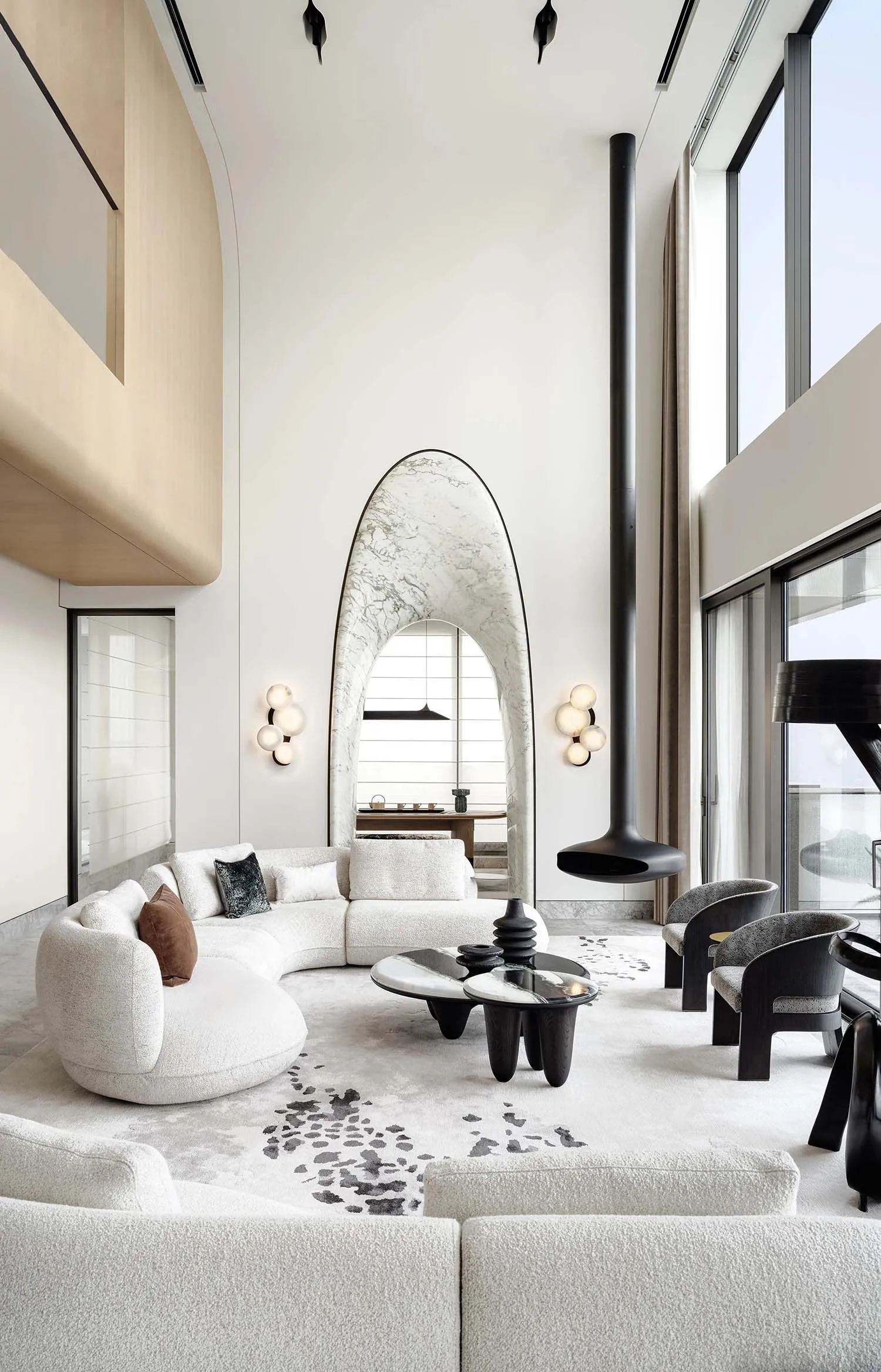 Modern living room featuring a white marble curtain, a sleek white sofa adorned with modern cushions, and a stylish black cof