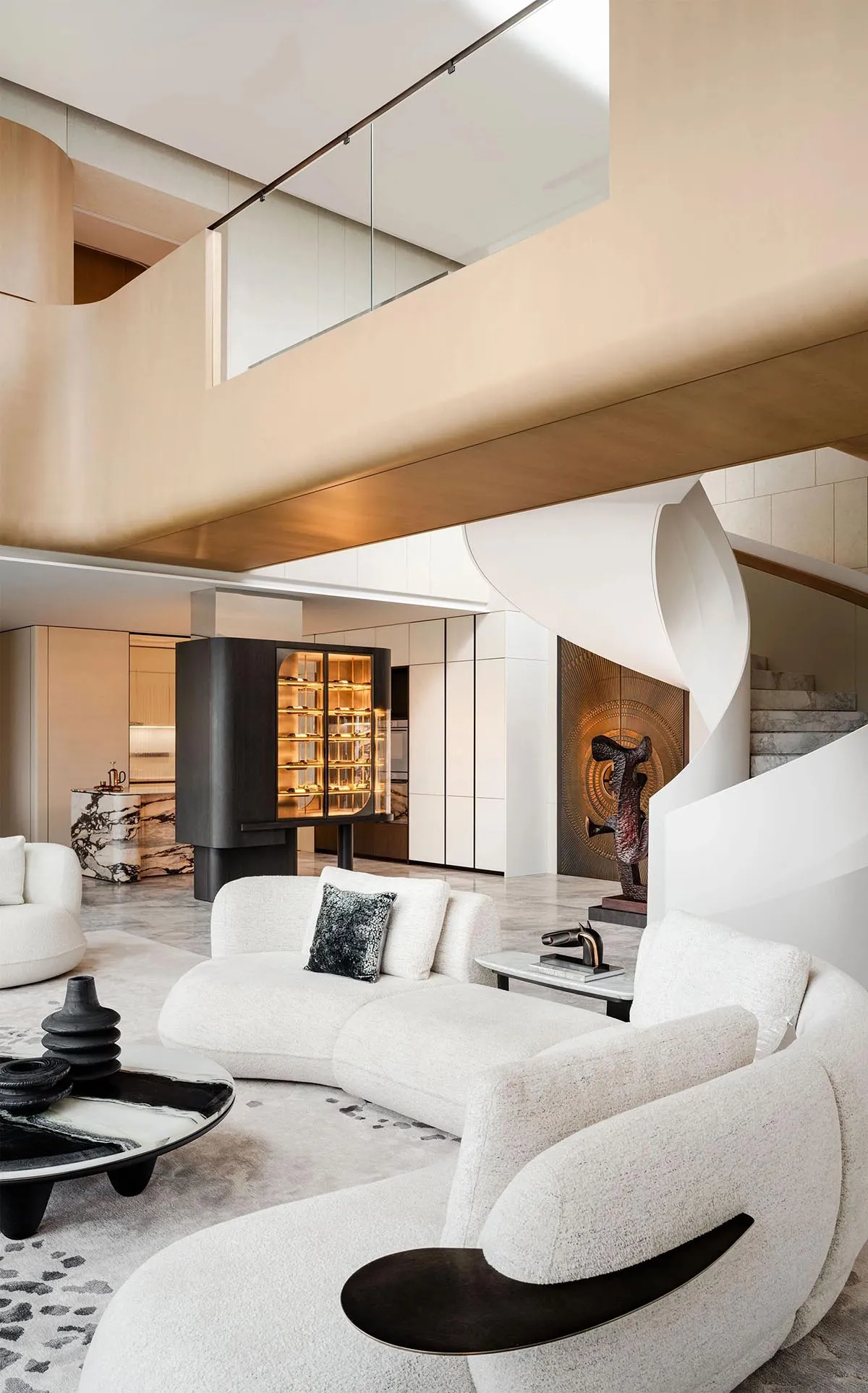 A modern living room featuring sleek, white furniture, a spiral staircase, and a wine cabinet with amber lighting.