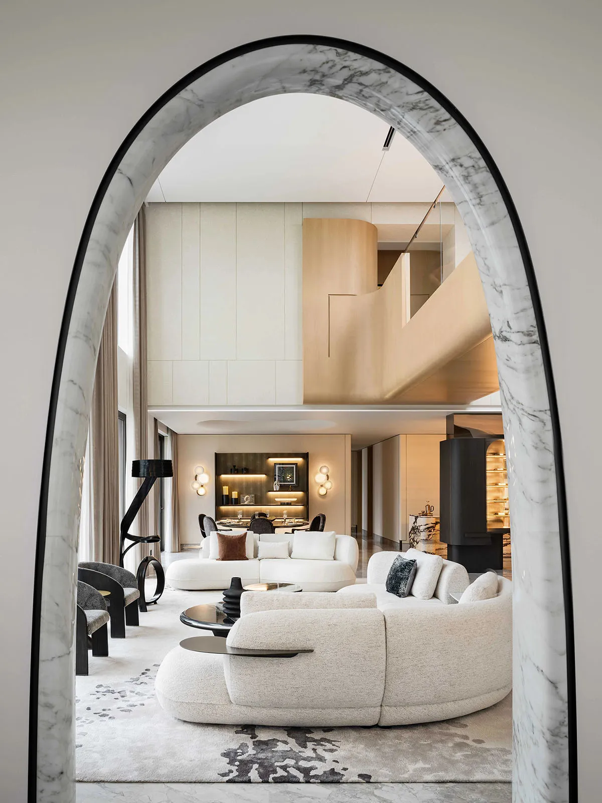 Modern living room with white sofas, minimalist decor, and a geometric archway