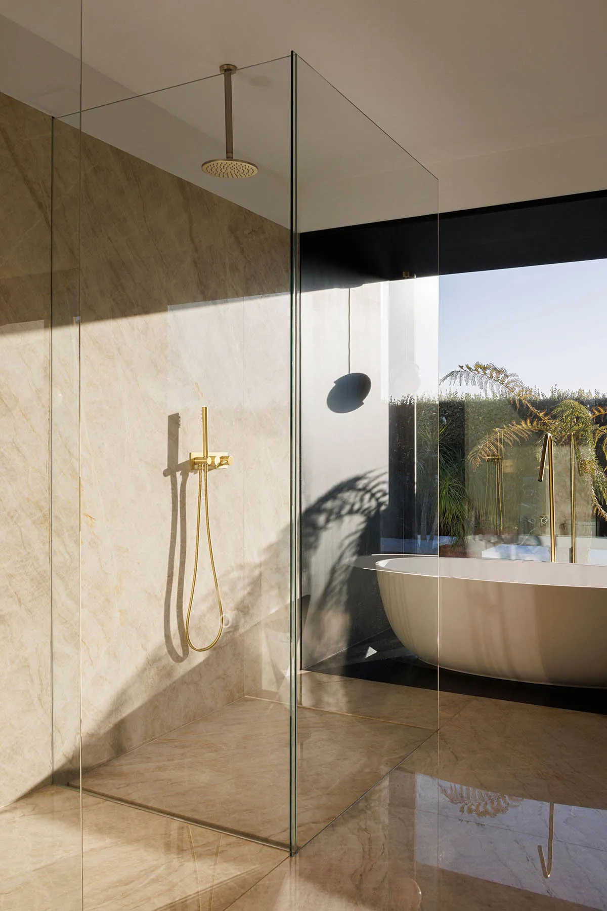 Modern minimalist bathroom designed with marble elements and a spacious tub with a view of the outdoors.