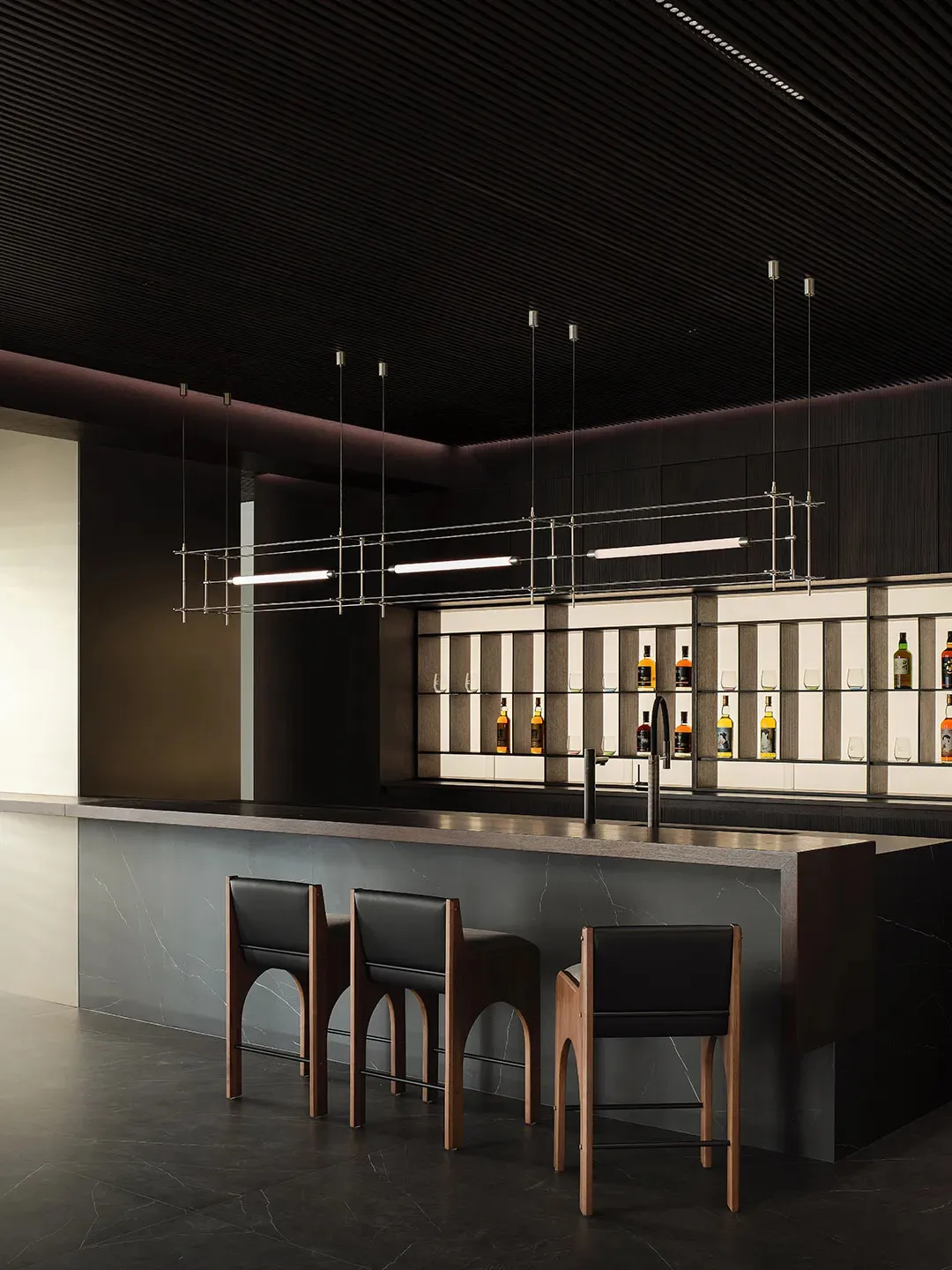 Modern bar with marble countertop, concrete accents, and metal pendant lights.