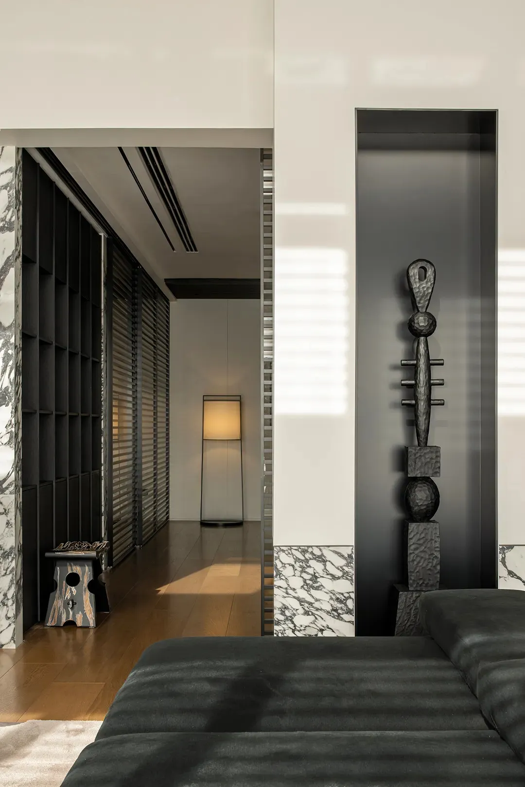 Modern bedroom with marble walls and metal sculpture