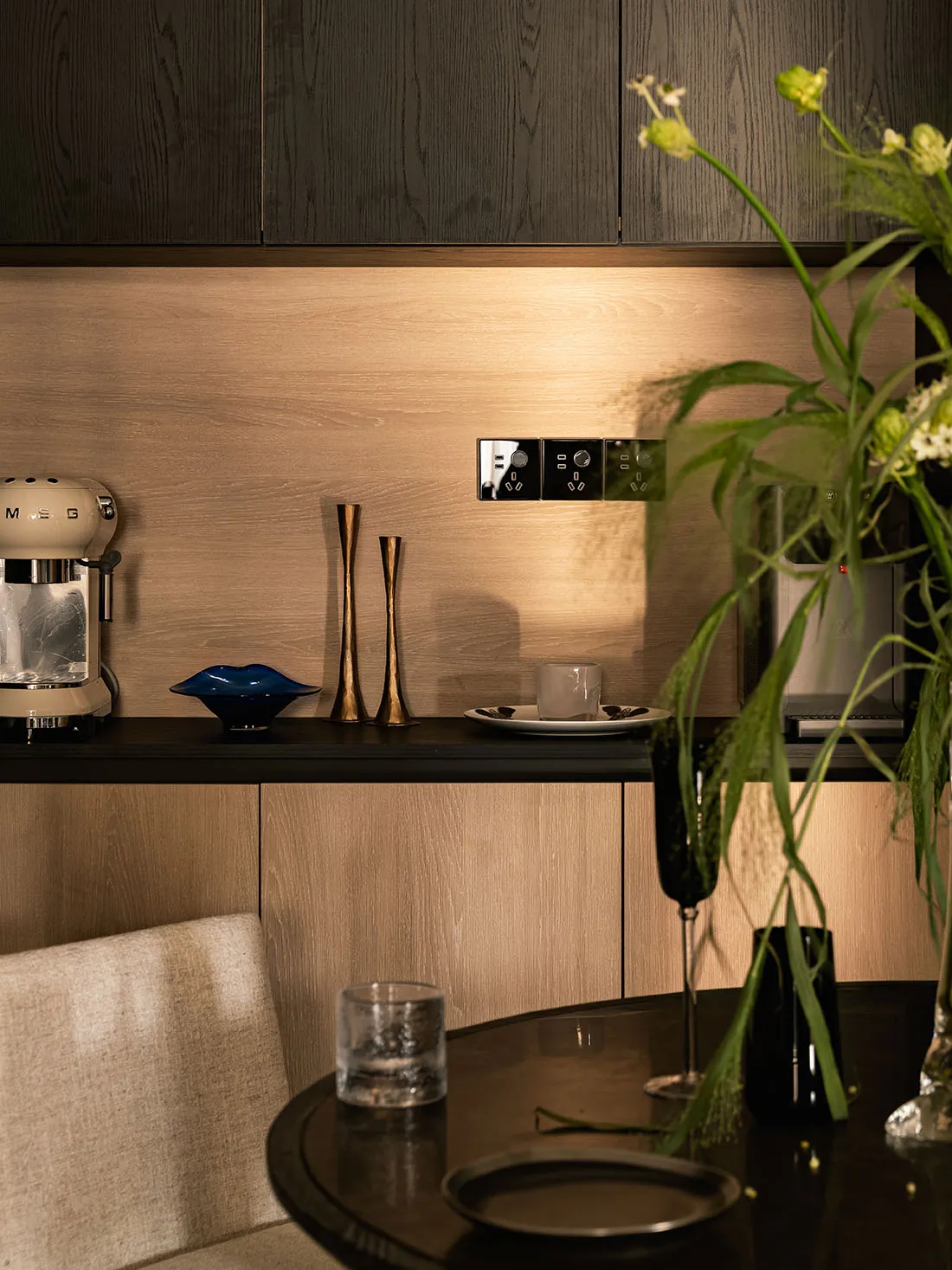 A minimalist residential kitchen featuring wooden cabinets with modern appliances and clean lines.