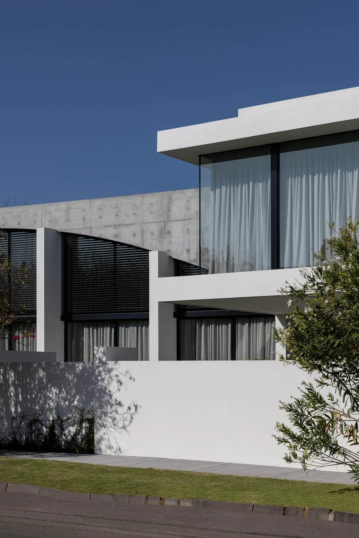 A modern residential home with concrete and glass exterior.