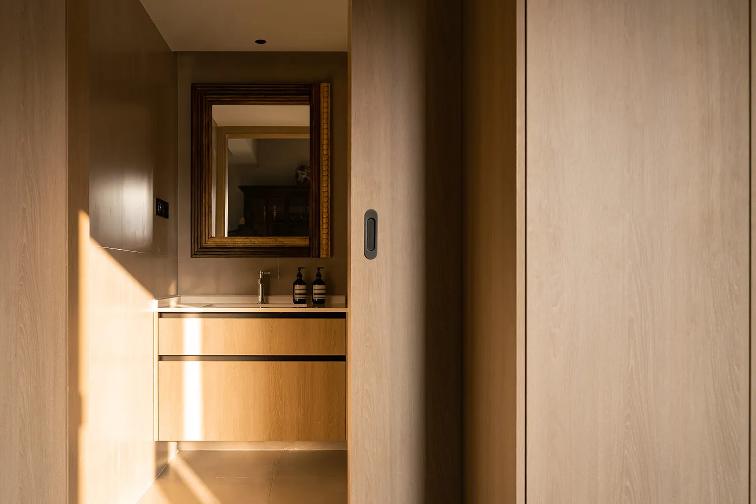 Minimalist bathroom featuring wooden fixtures and stone accents.