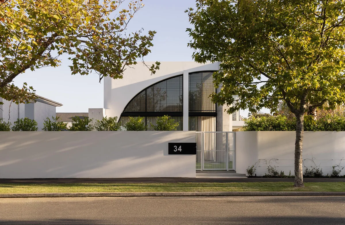 A modern residential exterior featuring white and glass concrete materials.