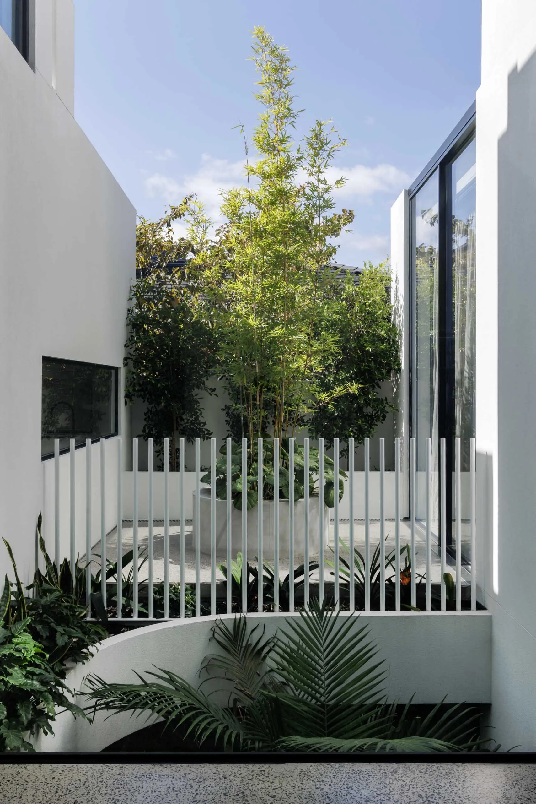 Modern interior and exterior of a residential house featuring a minimalist design with concrete walls and large glass windows