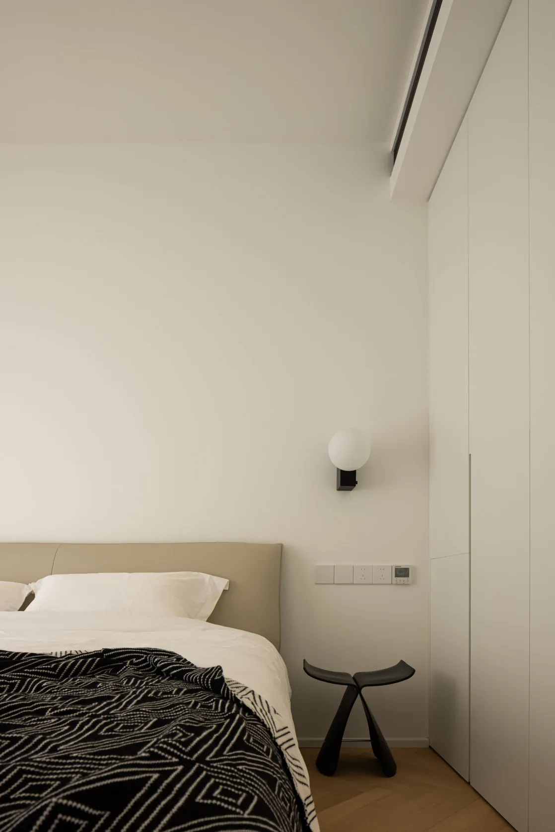Cushioned headboard and wooden floor in minimalist bedroom setting