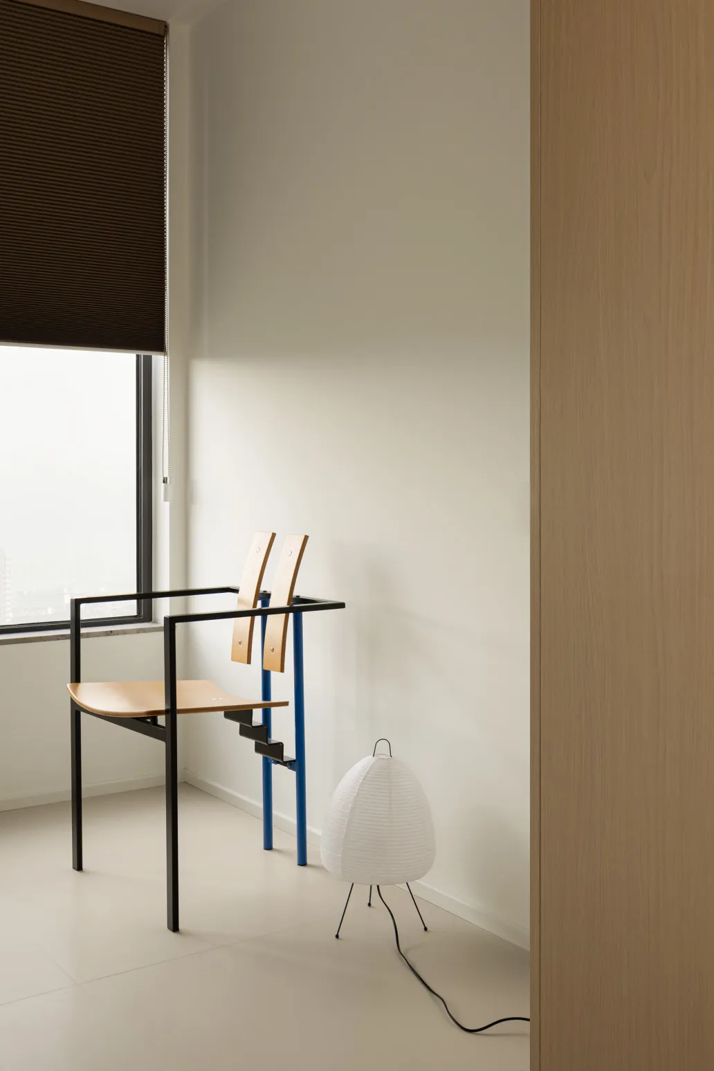 A minimalist room with wooden elements and a large window.