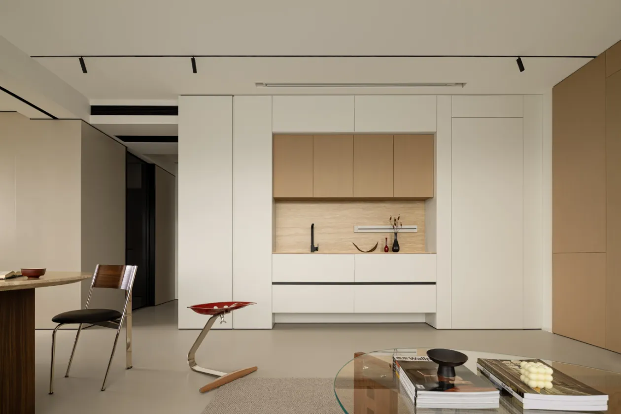 A minimalist kitchen featuring wood and white cabinets and countertops.
