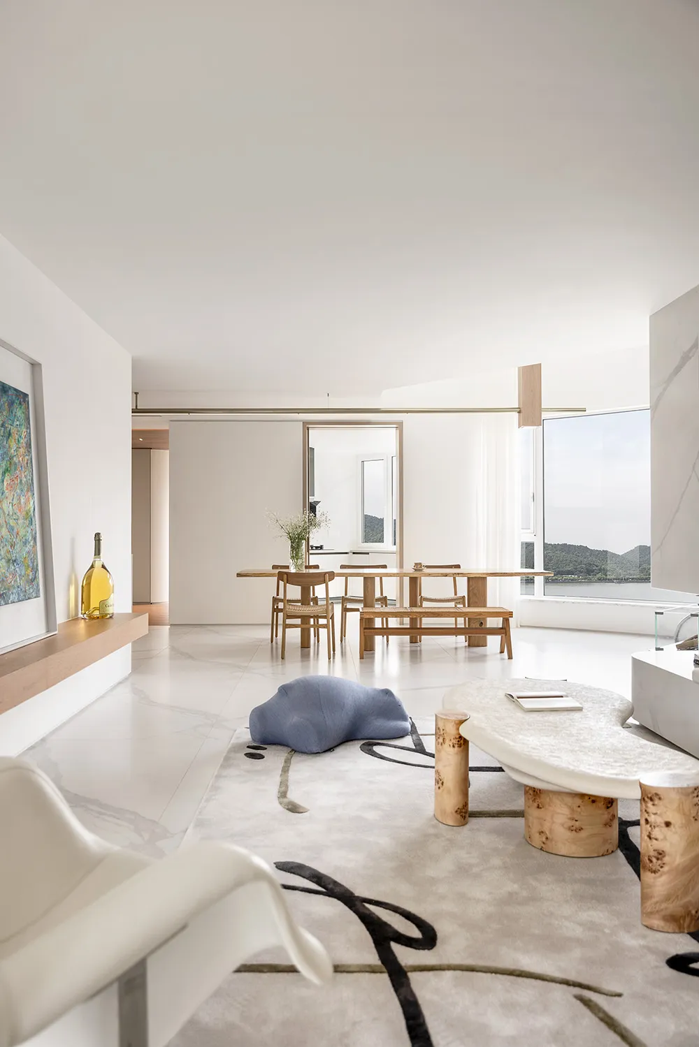 Modern living room interior with marble accents, minimalist design, and natural light.