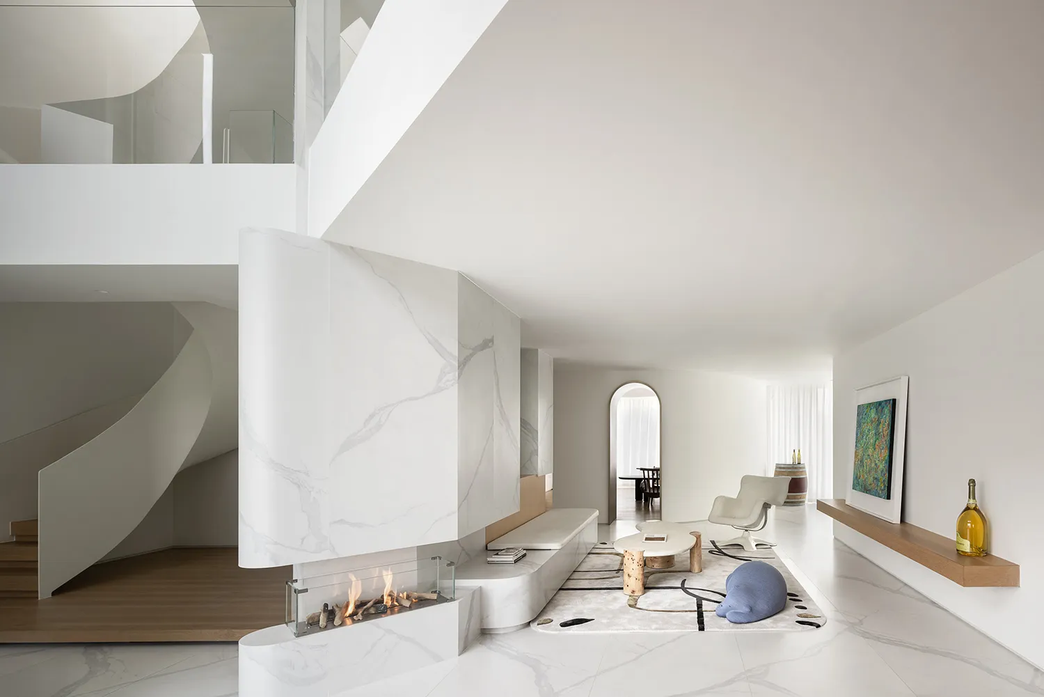 Modern minimalist living room with marble walls and floor, white furniture, and a spiral staircase.