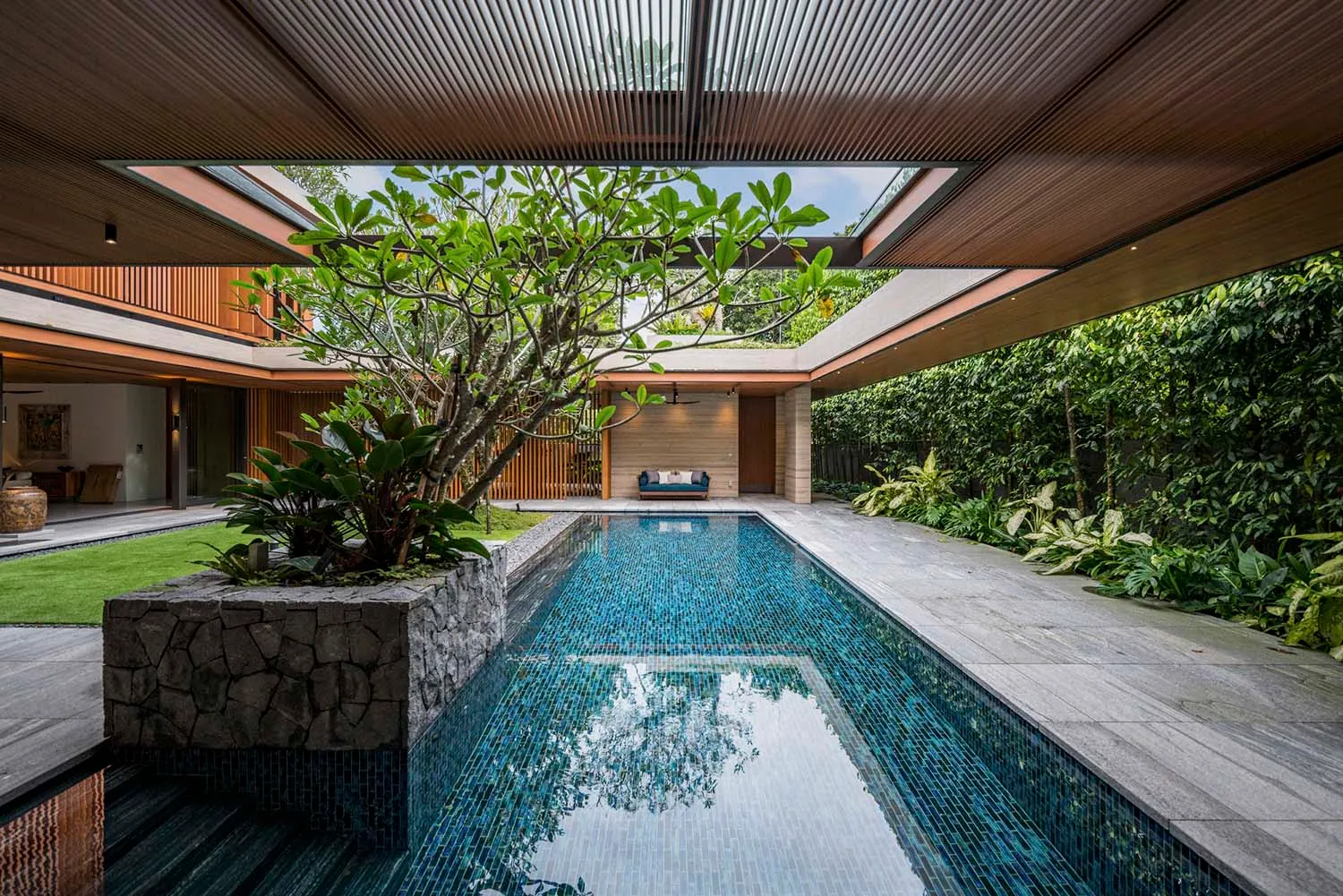 Modern residential interior featuring glass, concrete, and wooden elements.