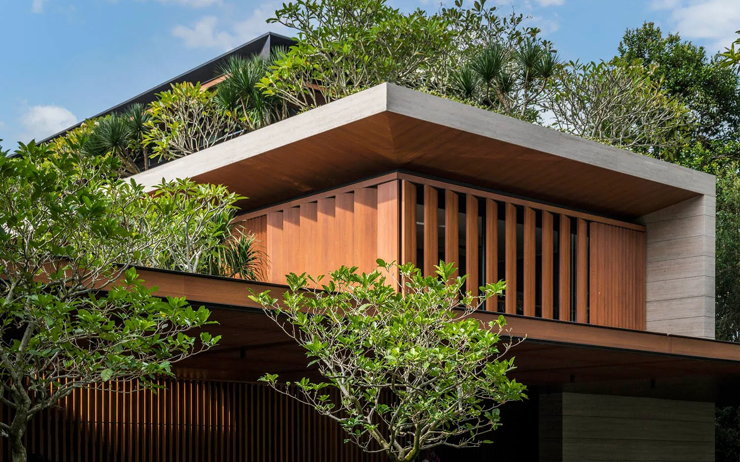 一座現代住宅建築採用木質與混凝土外觀，設有綠意盎然的屋頂花園。