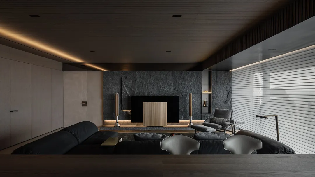 A modern living room with dark stone walls and a sleek black fireplace.
