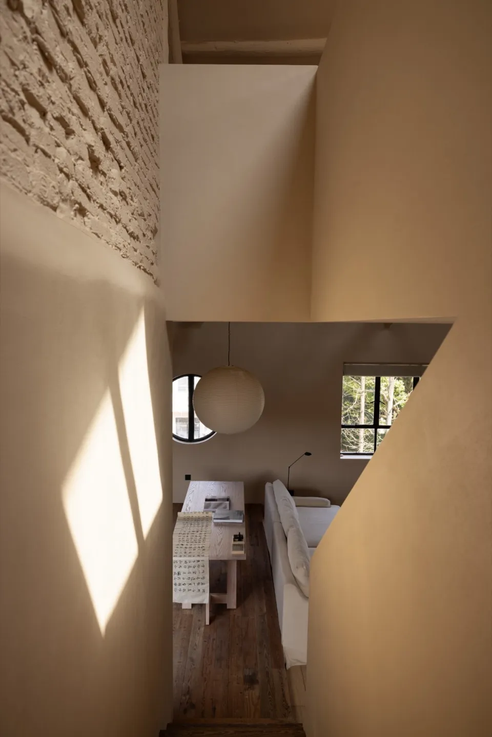 A modern minimalist living room with concrete walls and wooden furniture.