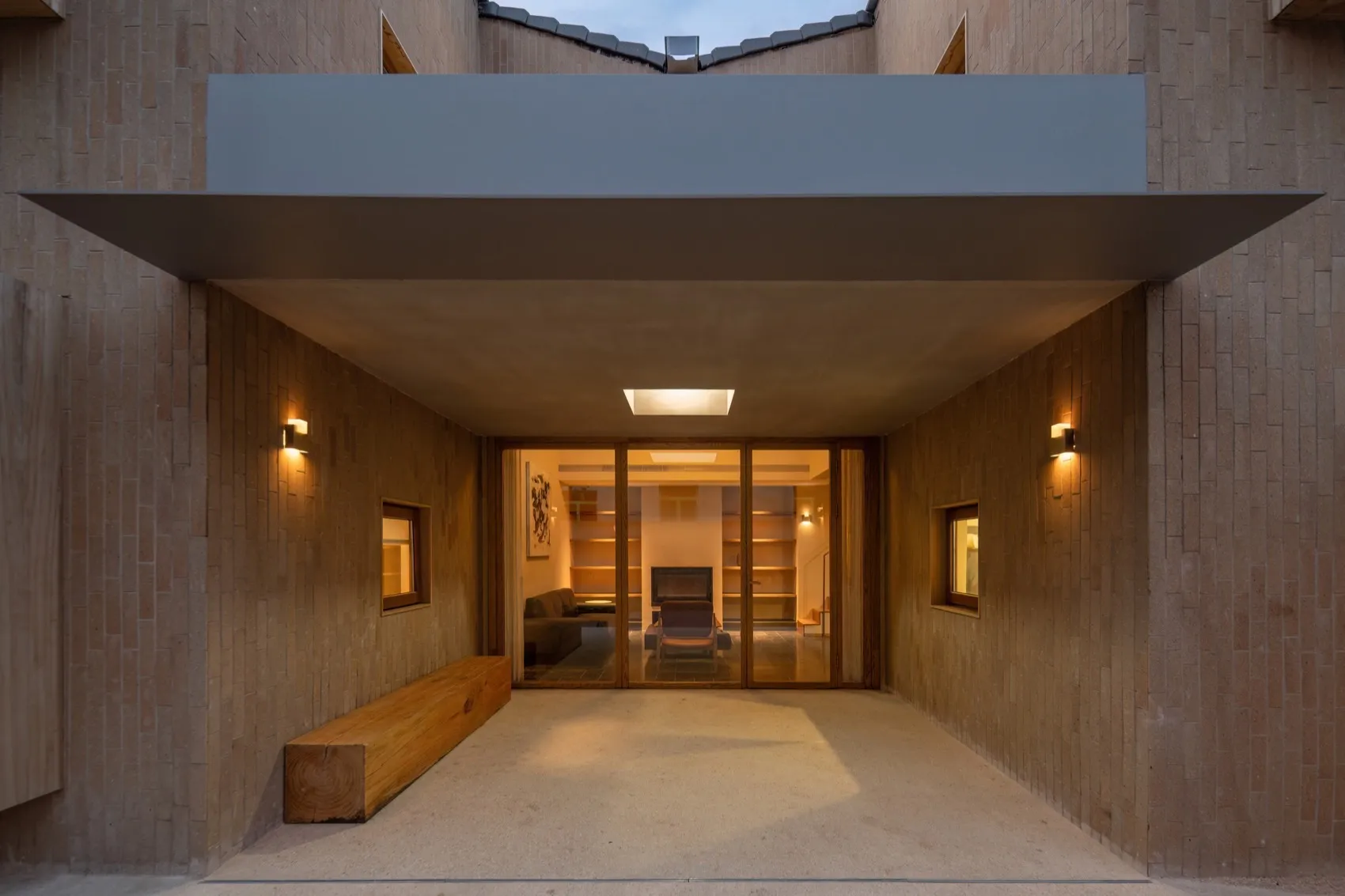 A modern entryway featuring a wooden portal and an illuminated interior space.