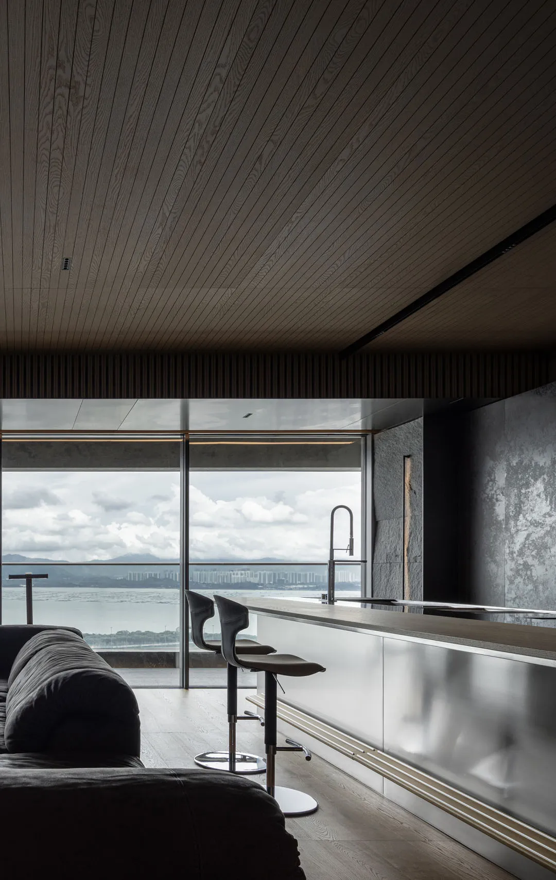 A sleek, modern kitchen bar area with metallic finishes and seating.