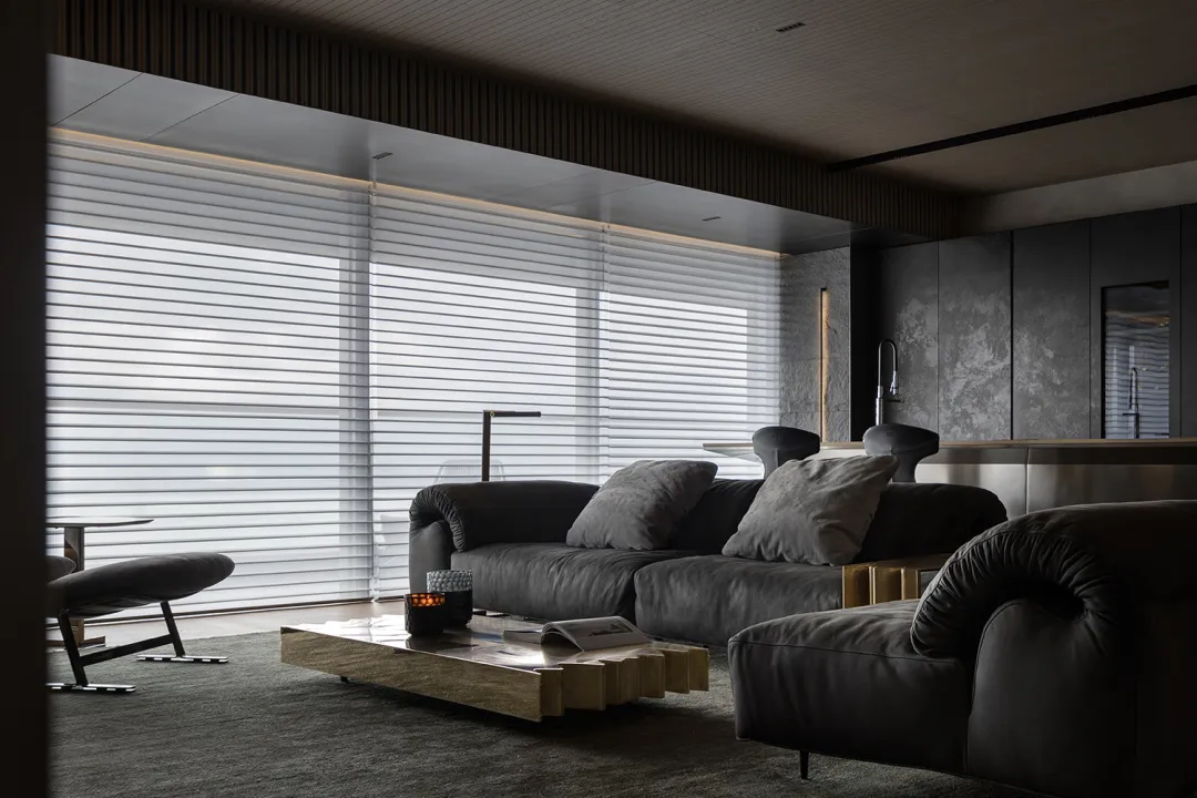 Modern living room with a metal coffee table, leather sofa, and stone accents.
