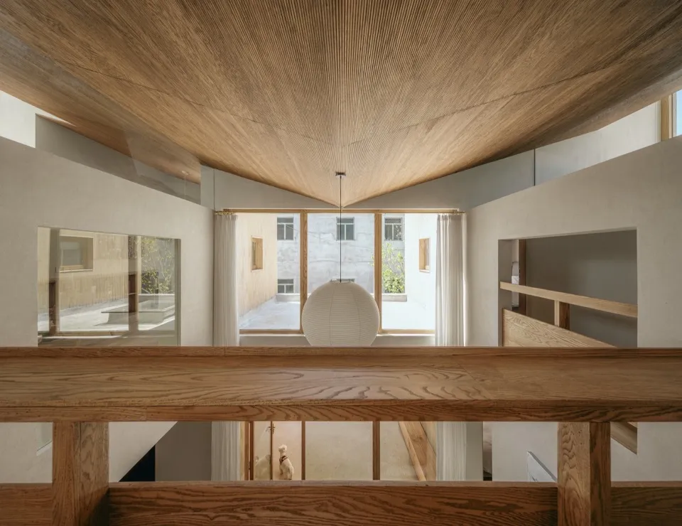A minimalist home interior with wooden elements and concrete walls.