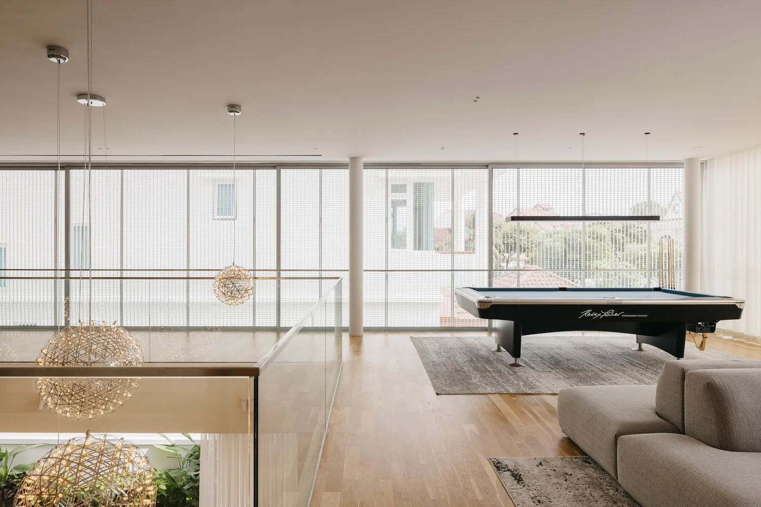 Modern interior design featuring contemporary metallic lighting fixtures and a sleek glass-couch in a spacious living area.