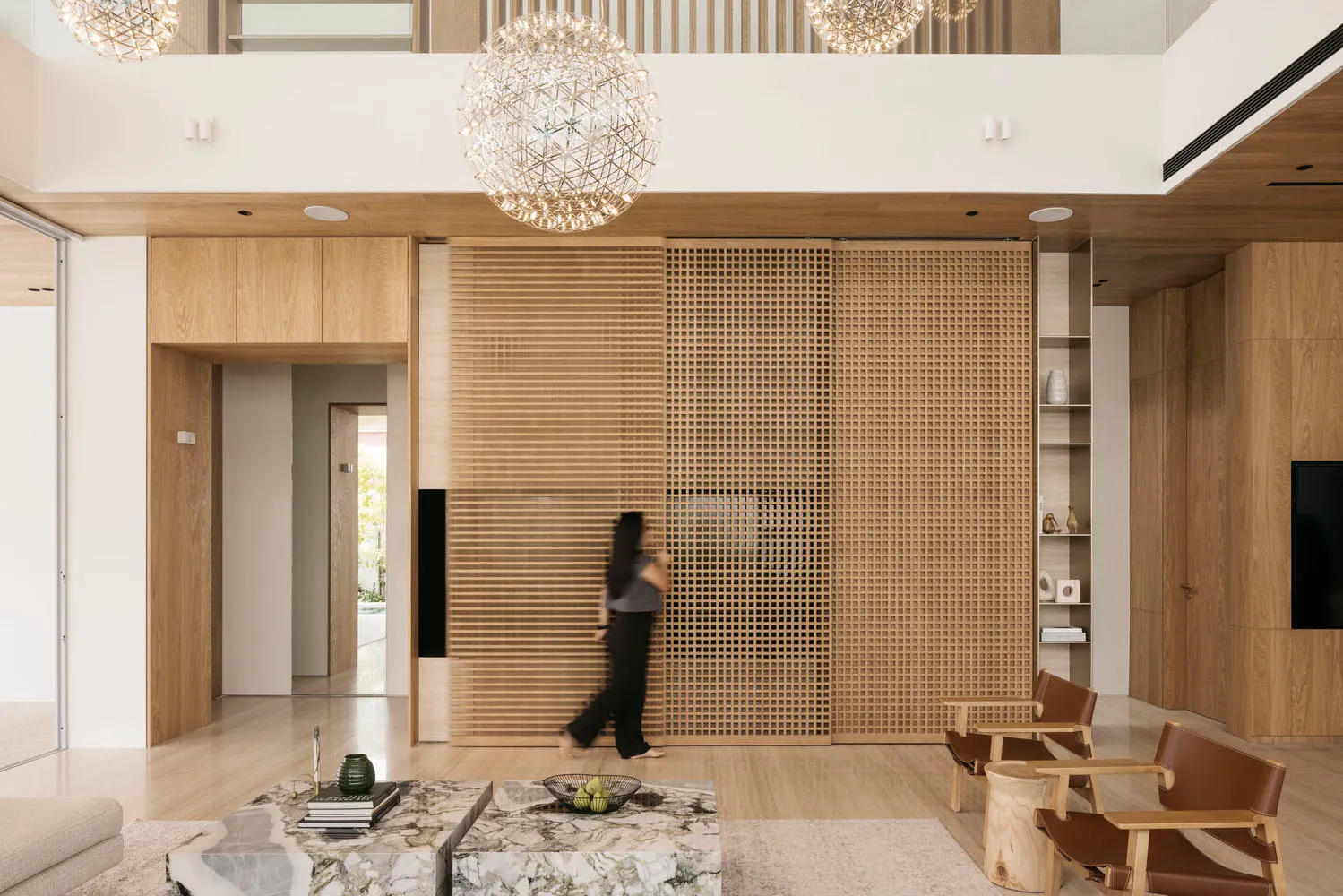 A modern minimalist living room featuring a wood sliding door and minimalist furniture.