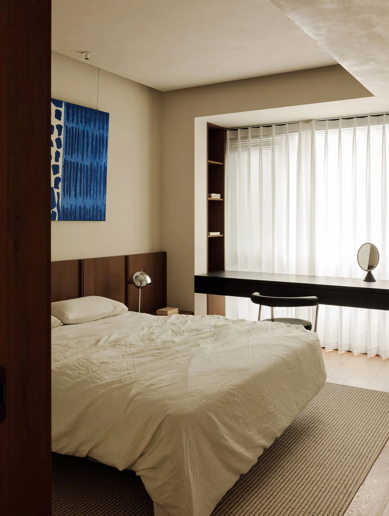Modern minimalist bedroom featuring a bed with white bedding, curtains, and a glass window.