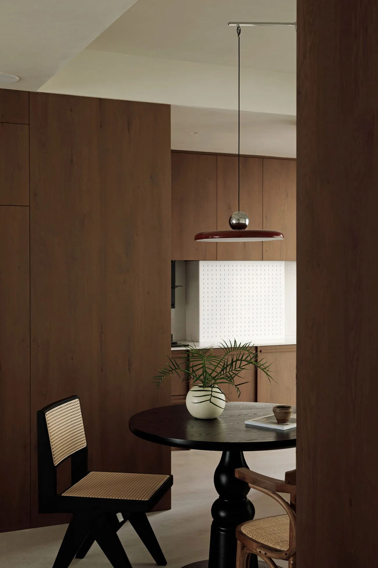 Minimalist dining room featuring wooden furniture and glass elements.