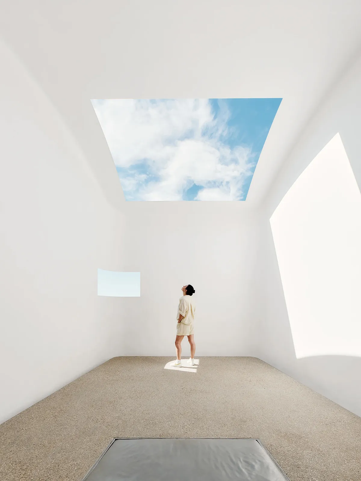 A minimalist sculpture gallery with concrete walls and natural light.
