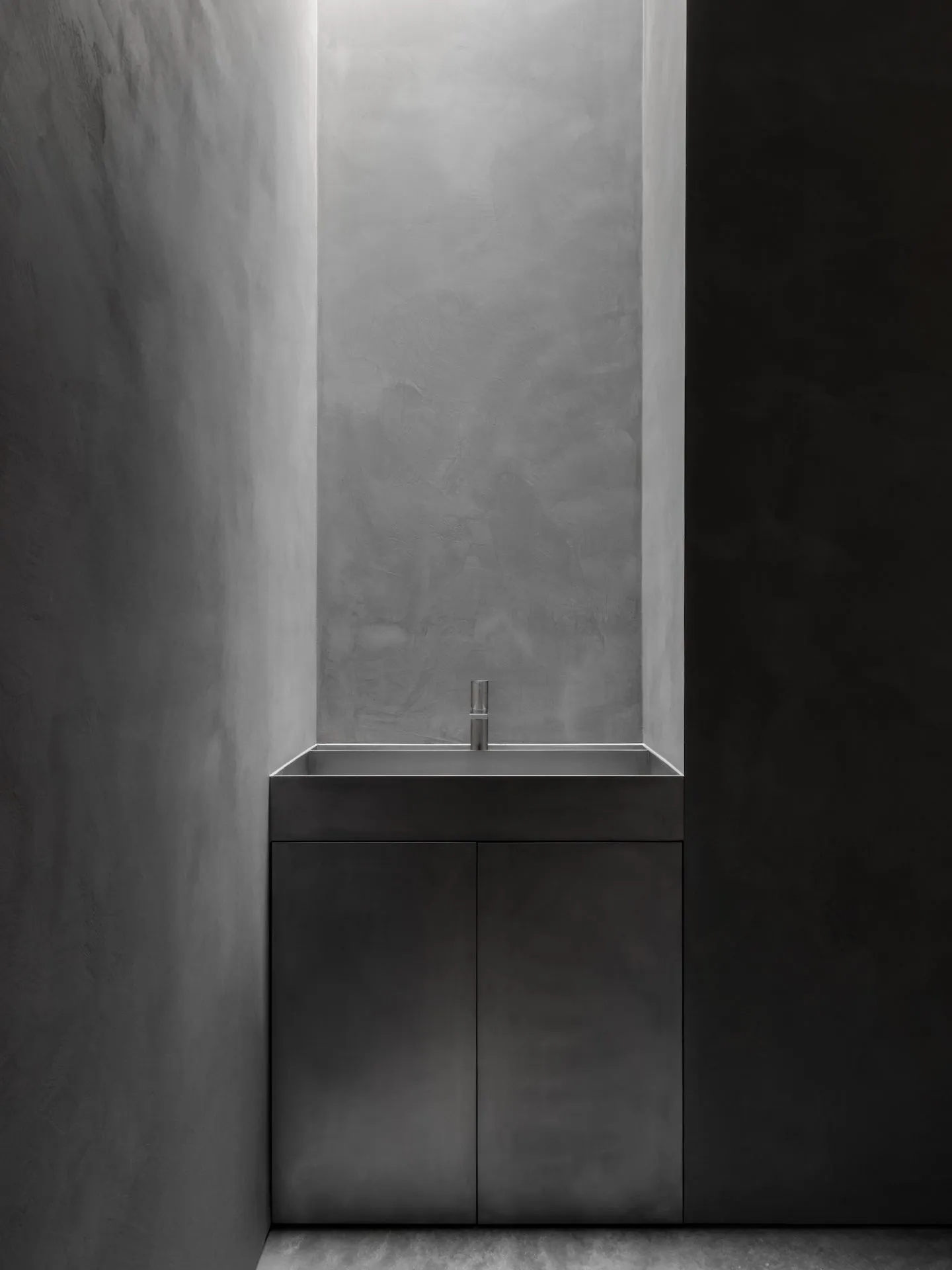 A sleek, modern concrete sink integrated into a minimalist bathroom design.