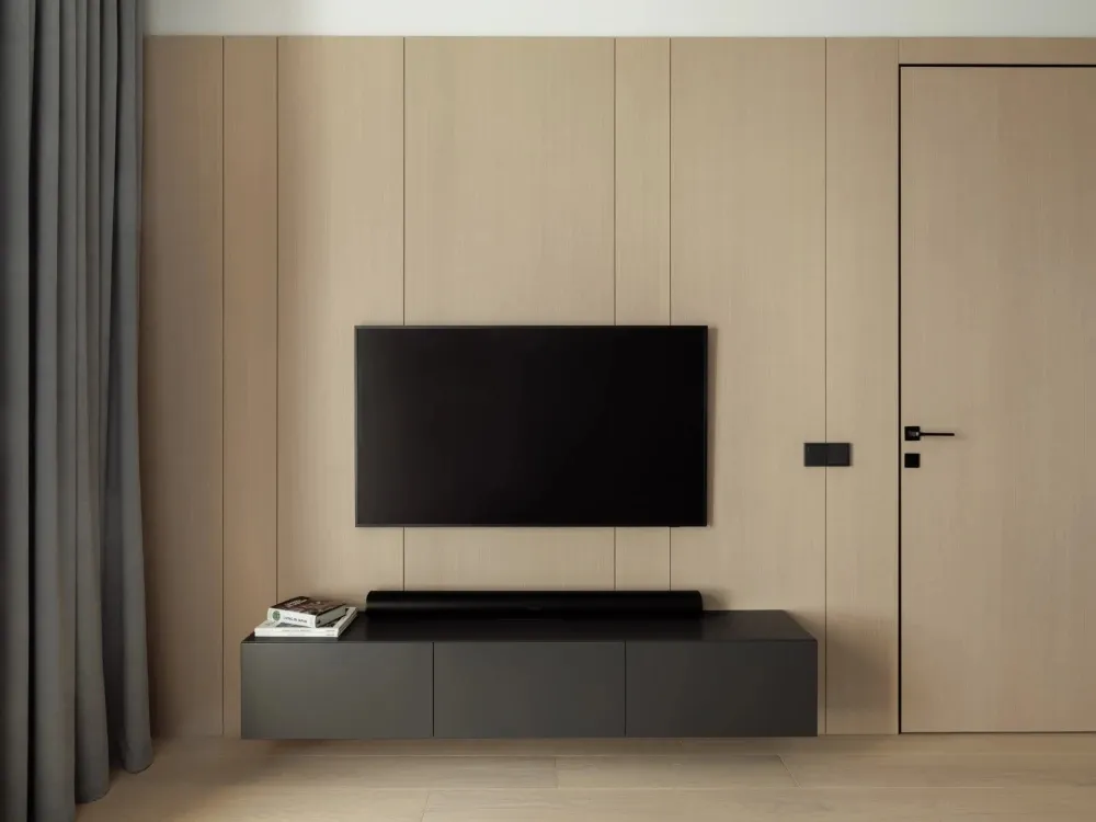 A modern living room with a wooden wall, a flat-screen TV mounted above a floating black console, and a black curtain on the