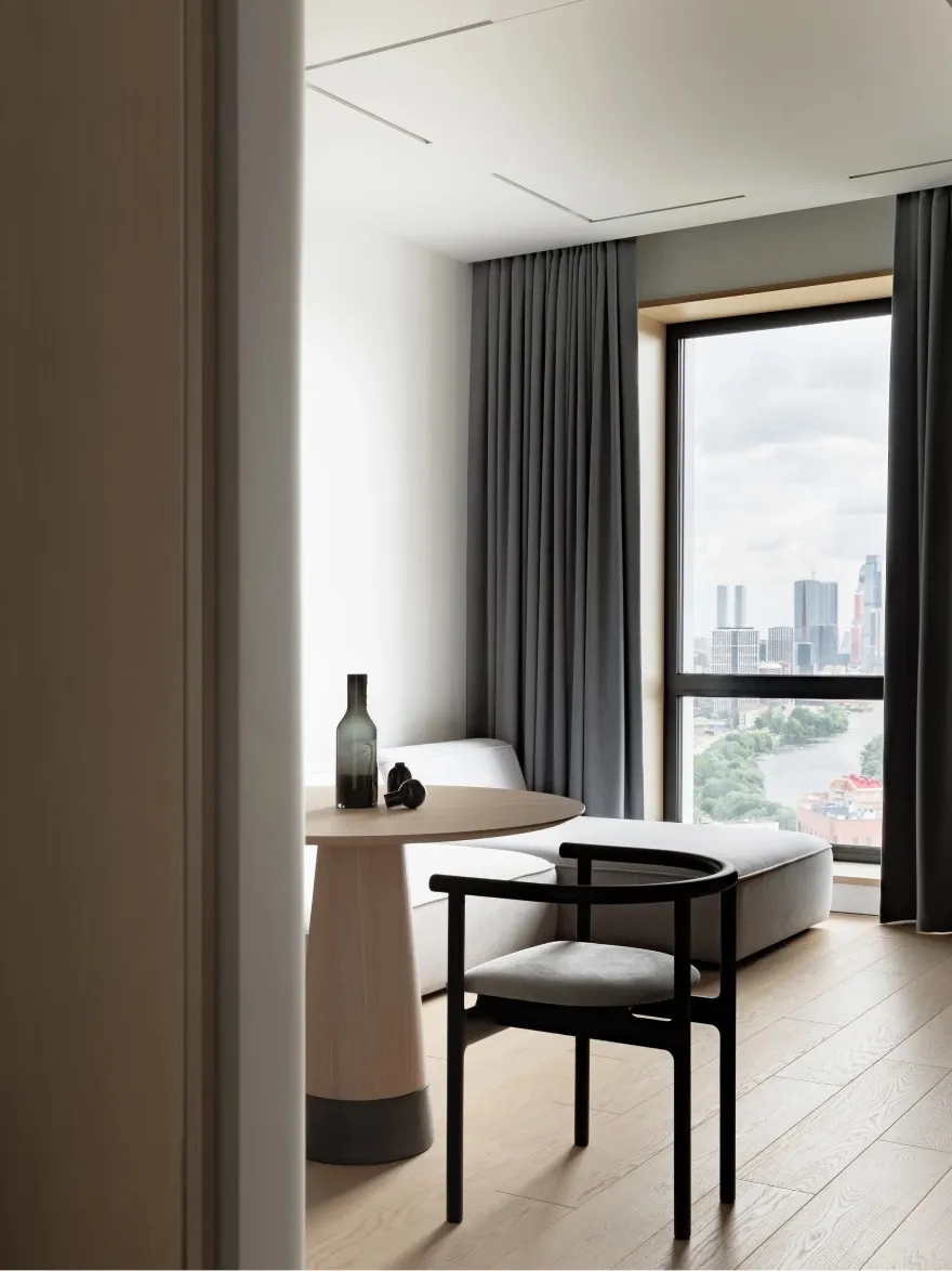Minimalist residential interior featuring a modern round table made of wood.