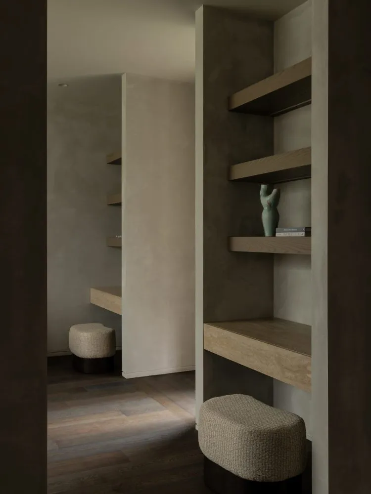 Minimalist living room featuring wooden shelves and contemporary seating.