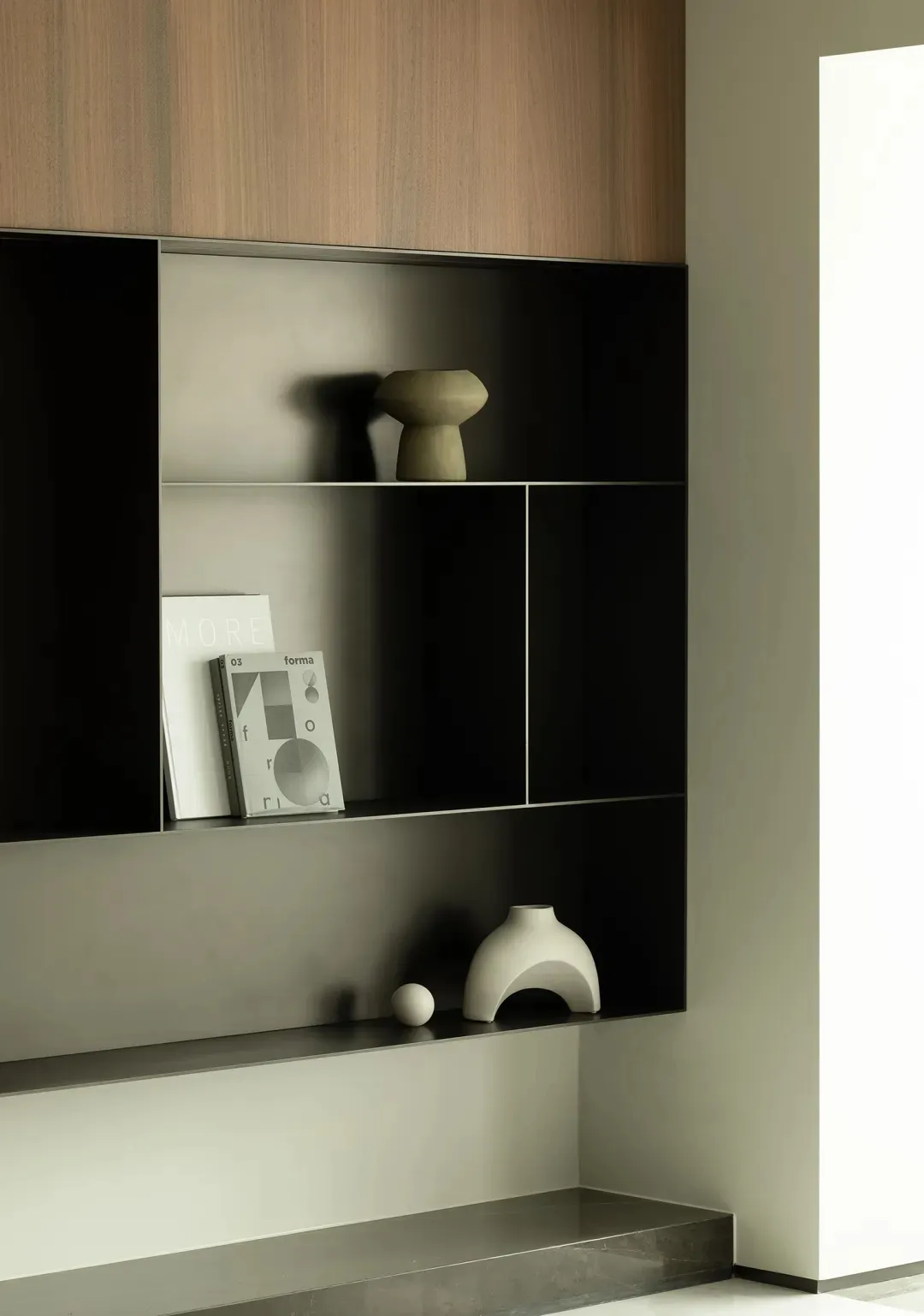 A modern interior design featuring black shelving with minimalist decorations and a clean, contemporary style.
