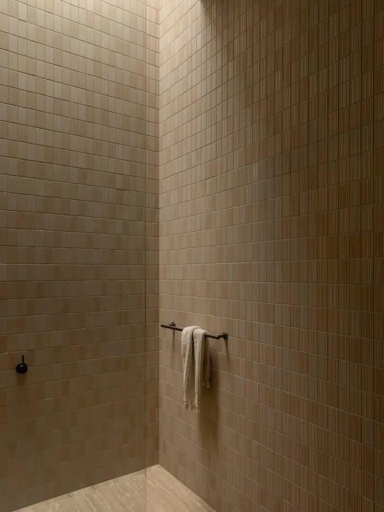 Modern bathroom interior with terrazzo tile walls, towel bar, and minimalist design.