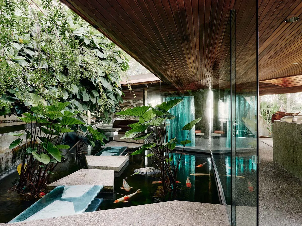 A modern interior design featuring a water pond with wood, concrete, and glass materials.