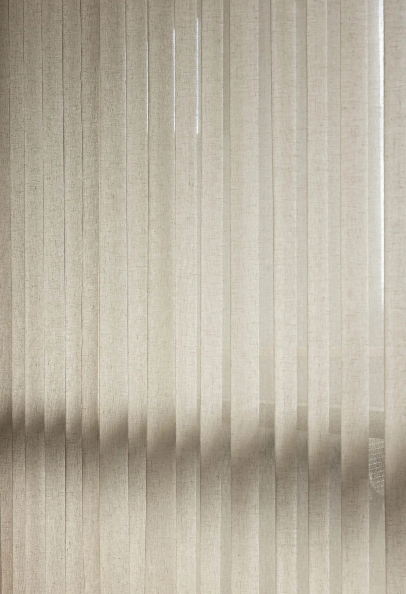 Striped taupe textile curtain hanging in a window.