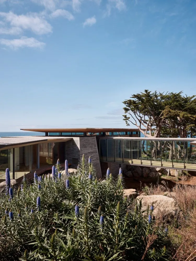 Modern architectural design featuring glass and stone materials.