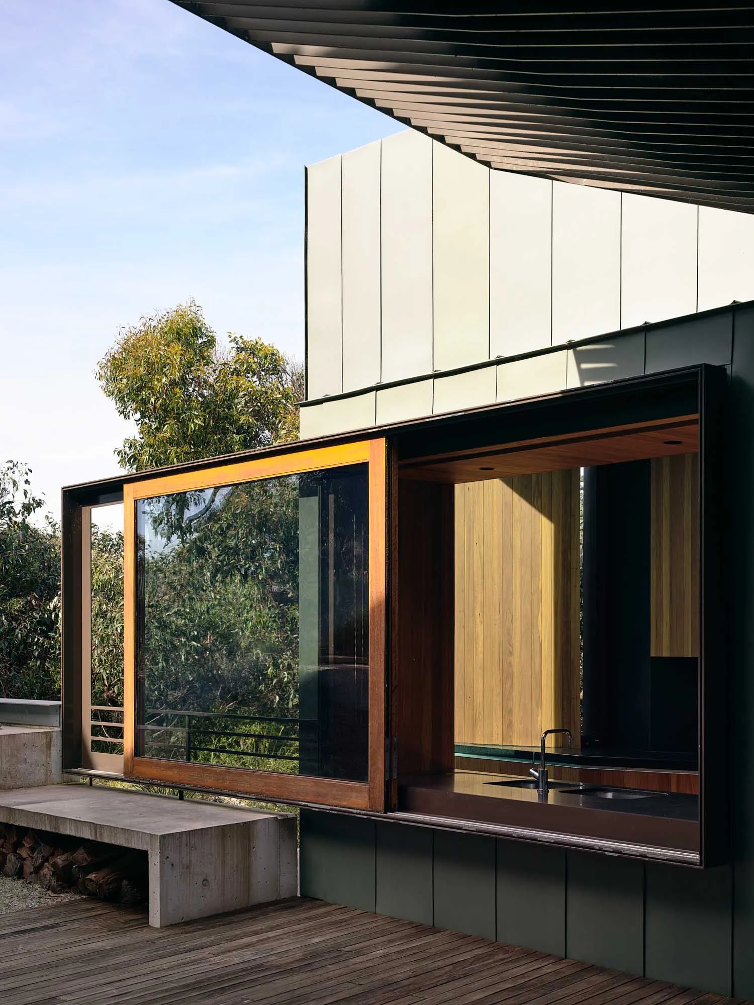 A modern house exterior with concrete walls and bamboo accents.