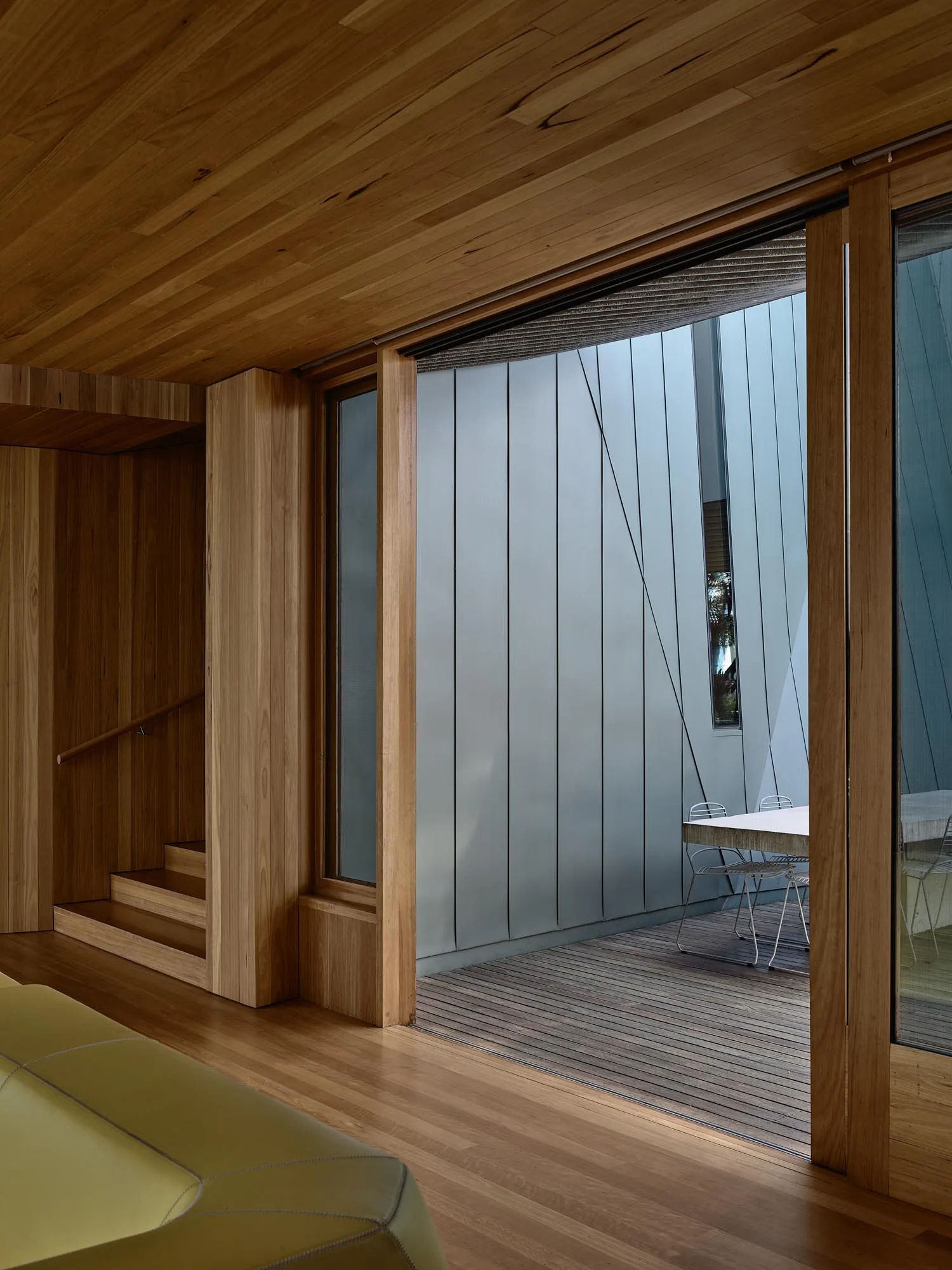 A modern patio featuring glass walls and sliding doors.